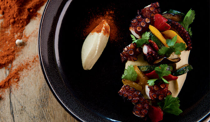 Poulpe grillé au paprika, purée de pois chiche persillée et légumes grillés