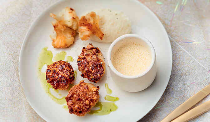 Noix de coquille Saint-Jacques poêlées en croûte de noisette, mousseline de chou-fleur, jus de persil et émulsion d’ail