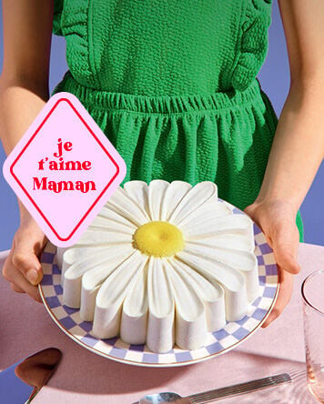 G&acirc;teau en forme de marguerite sur une assiette, tenu &agrave; la main, avec un message &laquo; je t&rsquo;aime maman &raquo; pour la F&ecirc;te des M&egrave;res