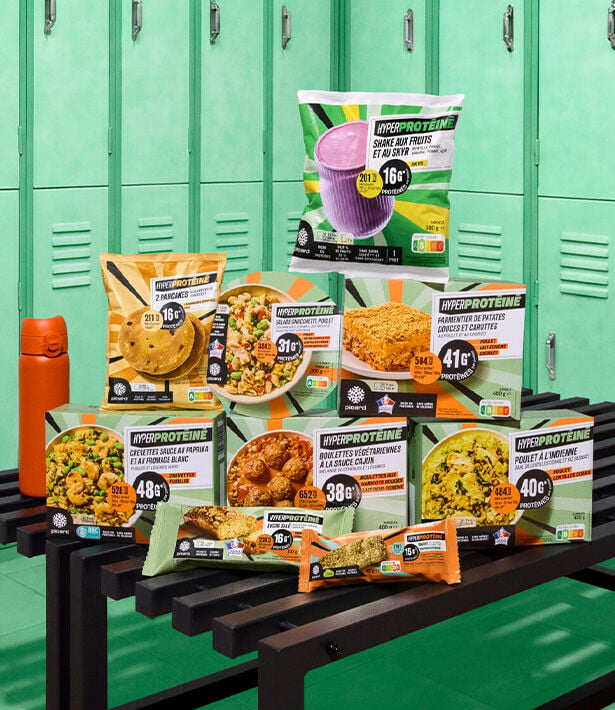 Gamme de produits hyperprot&eacute;in&eacute;s comprenant shakes, plats cuisin&eacute;s, biscuits et snacks, pr&eacute;sent&eacute;e sur un banc dans un vestiaire.